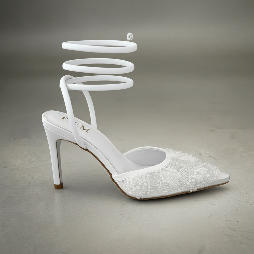 White high-heeled shoes with decorative pointed toes on a neutral background