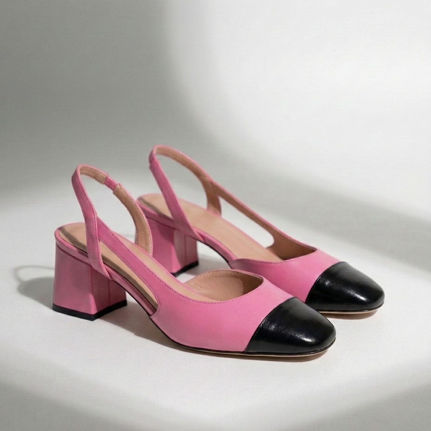Pink and black shoes on a light gray background