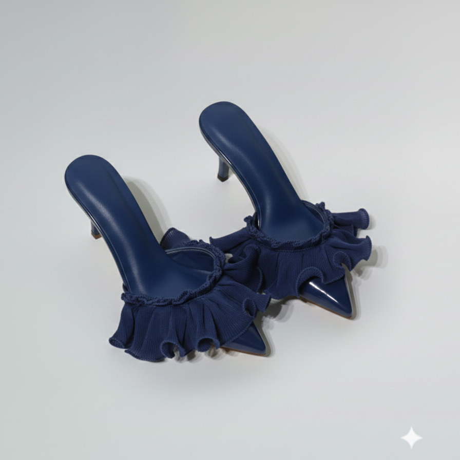 Pair of green high-heeled shoes with ruffled details on a white background