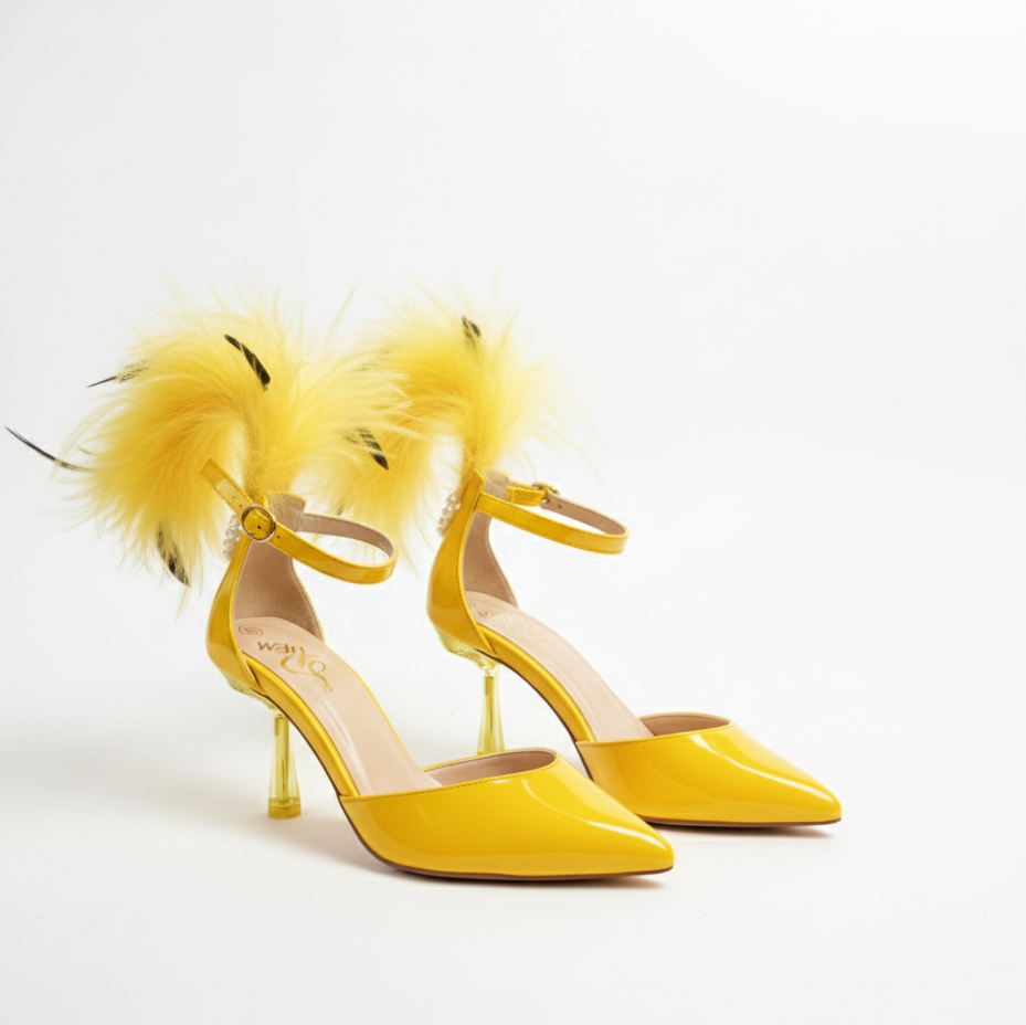 Yellow high-heeled shoes with feather details on a white background