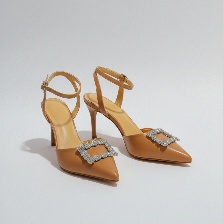 Tan high-heeled shoes with decorative buckles on a light gray background