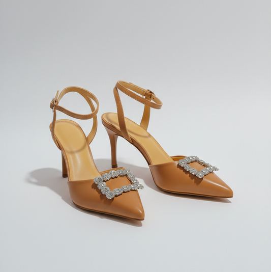 Tan high-heeled shoes with decorative buckles on a light gray background