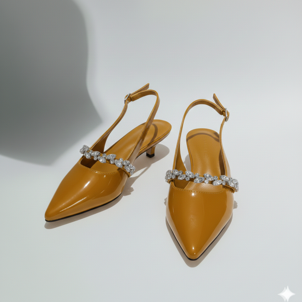 Pair of tan high-heeled shoes with decorative straps on a light gray background