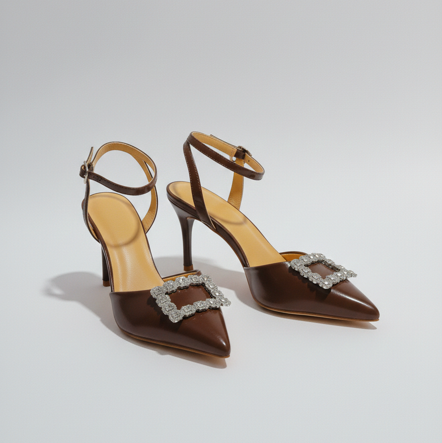 Brown high-heeled shoes with decorative buckles on a light gray background