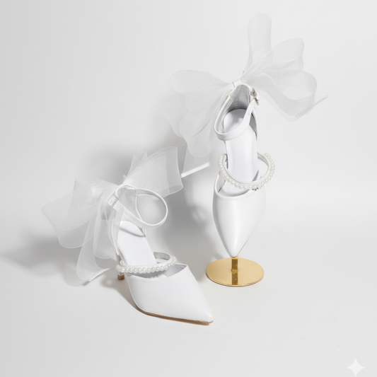 White high-heeled shoes with a gold sole on a white background