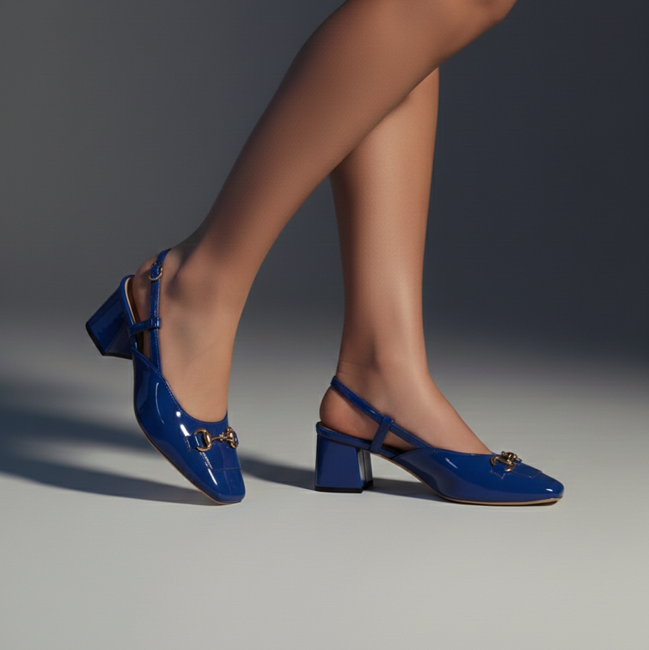 Blue high-heeled shoes worn by a person on a gray background