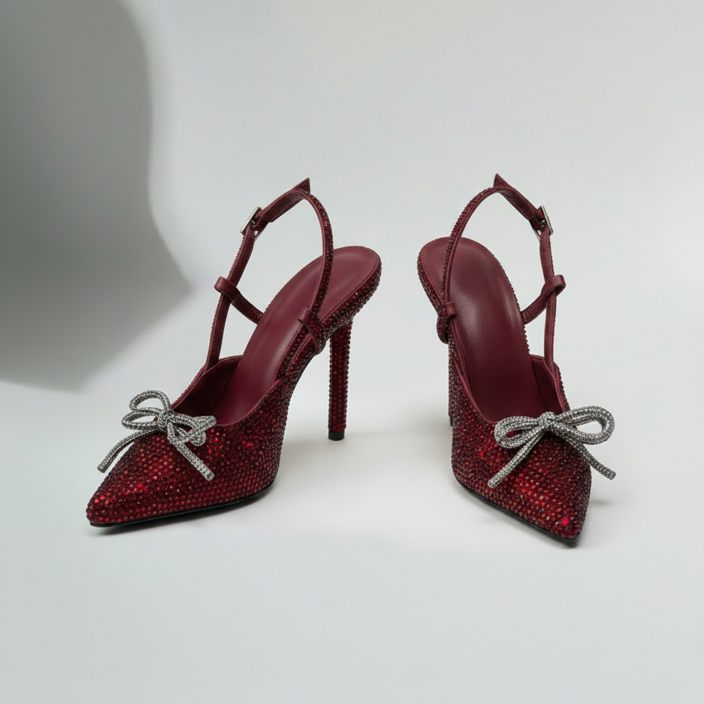 Pink high-heeled shoes with rhinestone embellishments on a light gray background