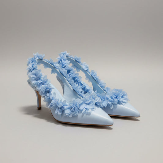 Pair of light blue floral shoes on a peach background