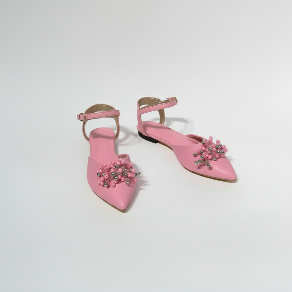 Pair of pink shoes with floral embellishments on a white background